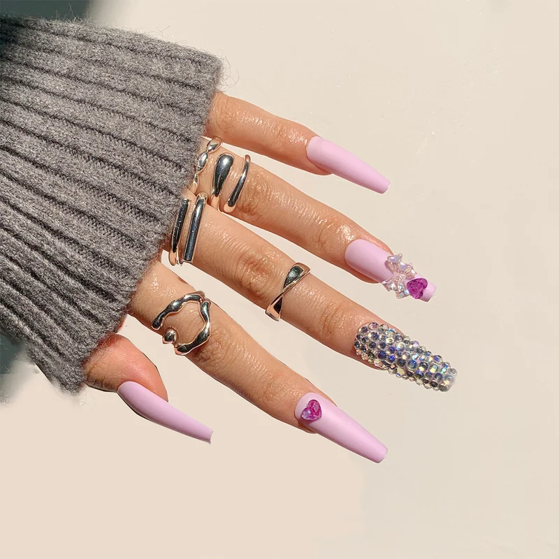 Kunstvolle Stiletto-Nägel mit Glitzer- und Blumenverzierungen Karnz