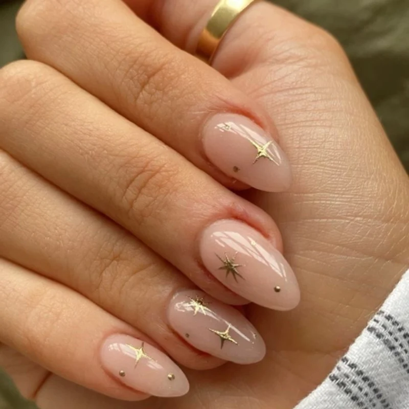 Kunstvolle Stiletto-Nägel mit glänzenden Sternenakzenten Karnz