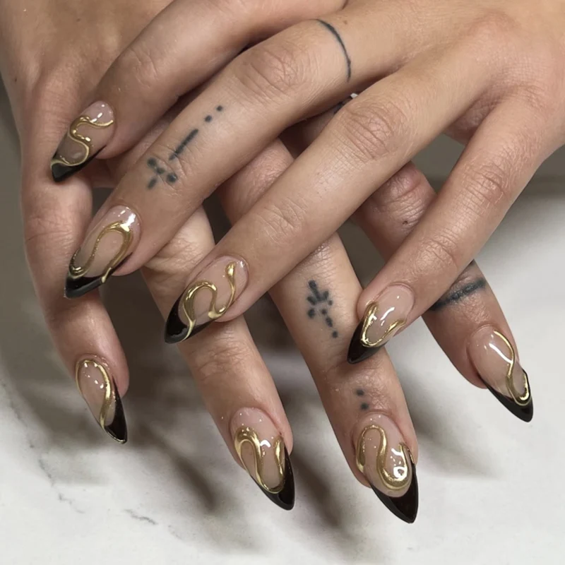 Kunstvolle Stiletto-Nägel mit elegantem Gold-Design Karnz