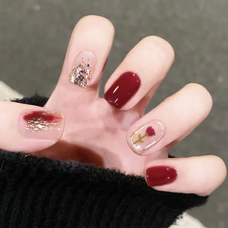 Elegantes Nageldesign mit floralen und glitzernden Akzenten Karnz
