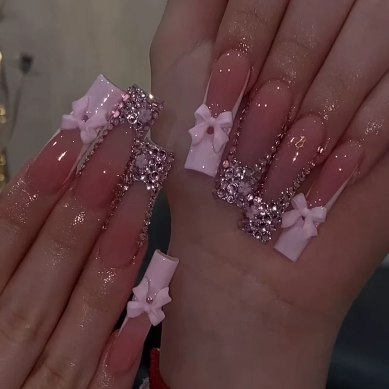 Kunstvolle Nagelkunst mit Strassverzierungen und Schleifen Karnz