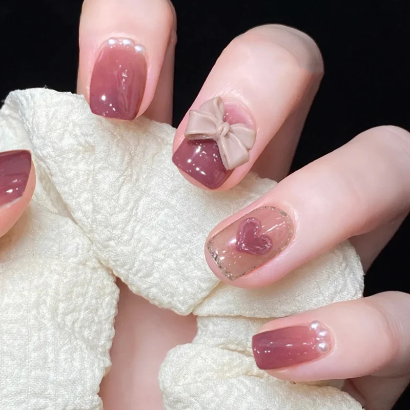 Kunstvolle Nagelkunst mit Schleifen- und Herzdesign Karnz