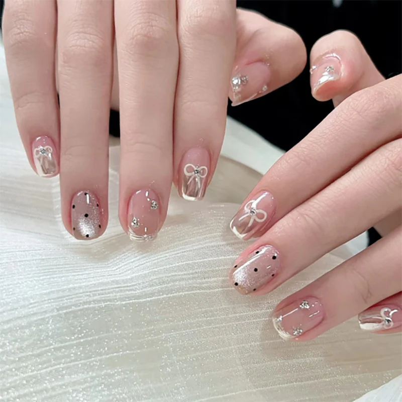 Kunstvolle Nagelkunst mit Schleifen- und Glitzerakzenten Karnz