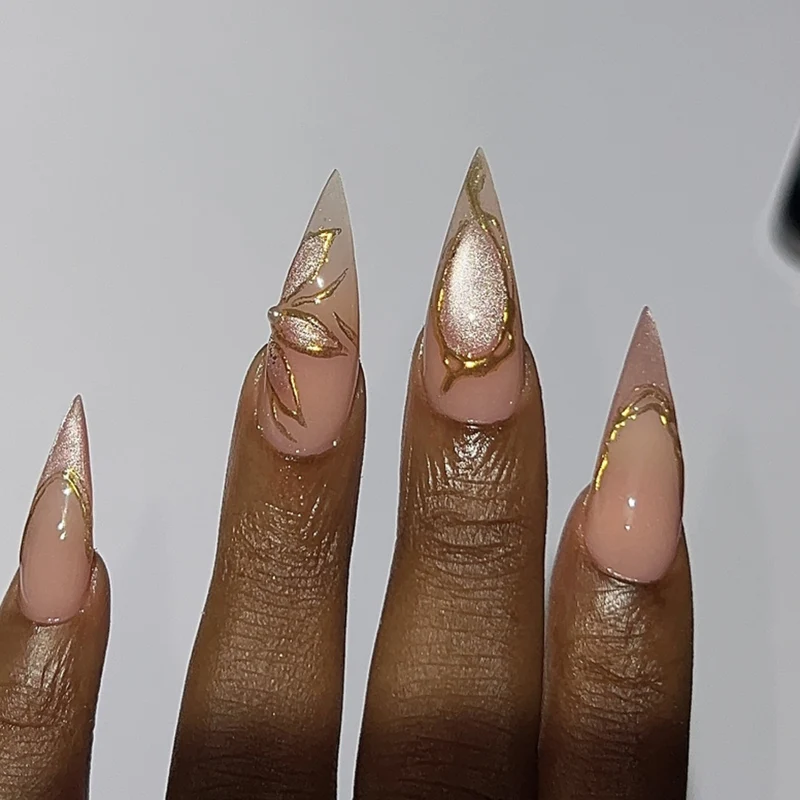 Kunstvolle Stiletto-Nägel mit Goldakzenten Karnz