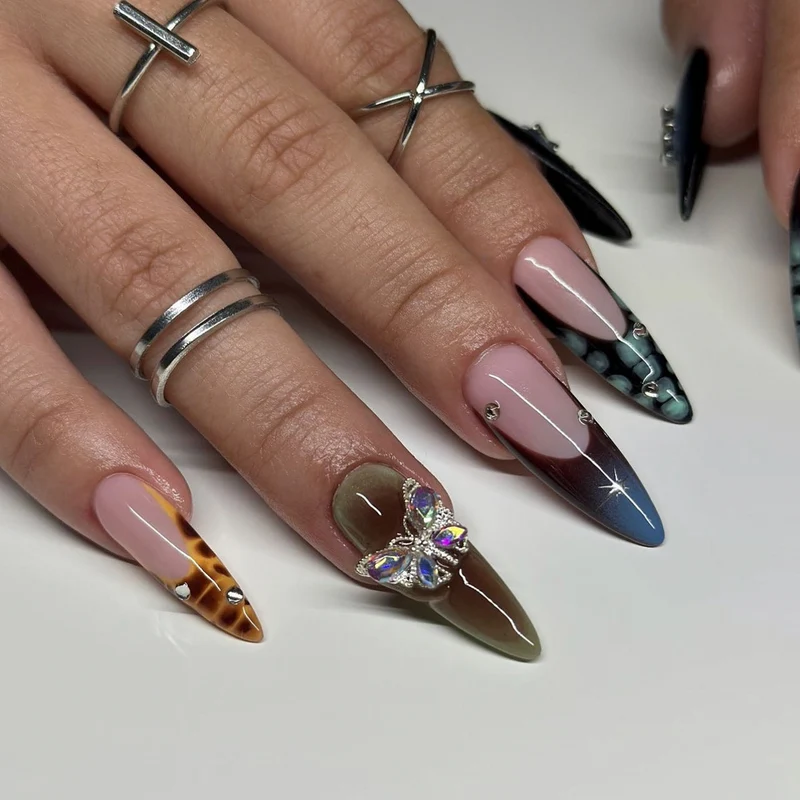 Kunstvolle Nagelverlängerungen mit eleganten Designs und Glitzer Karnz