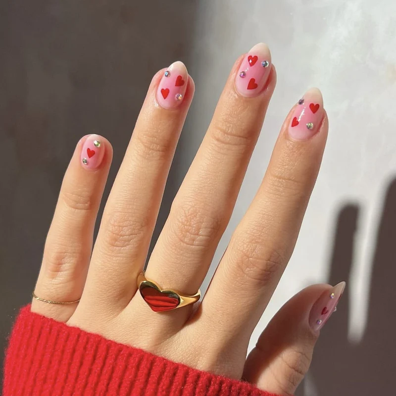 Kunstvolle Nagelkunst mit Herzmotiven und glamourösen Details Karnz