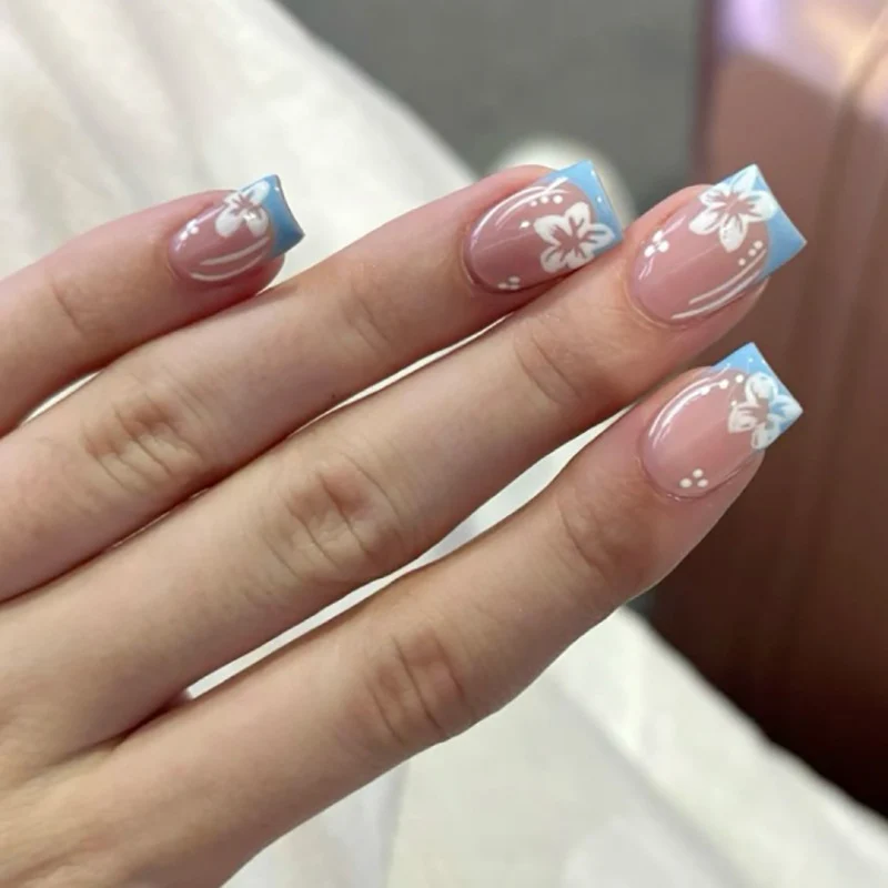 Kunstvolle Nagelkunst mit floralem Design und elegantem French-Tip Karnz