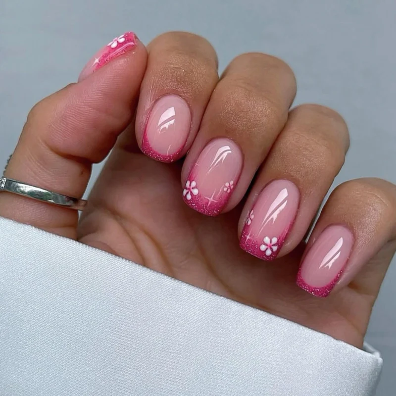 Kunstvolle Nagelkunst mit floralem Akzent und Glitzer Karnz