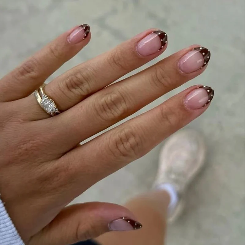 Kunstvolle Nagelkunst mit eleganten French-Spitzen und Glitzerakzenten Karnz