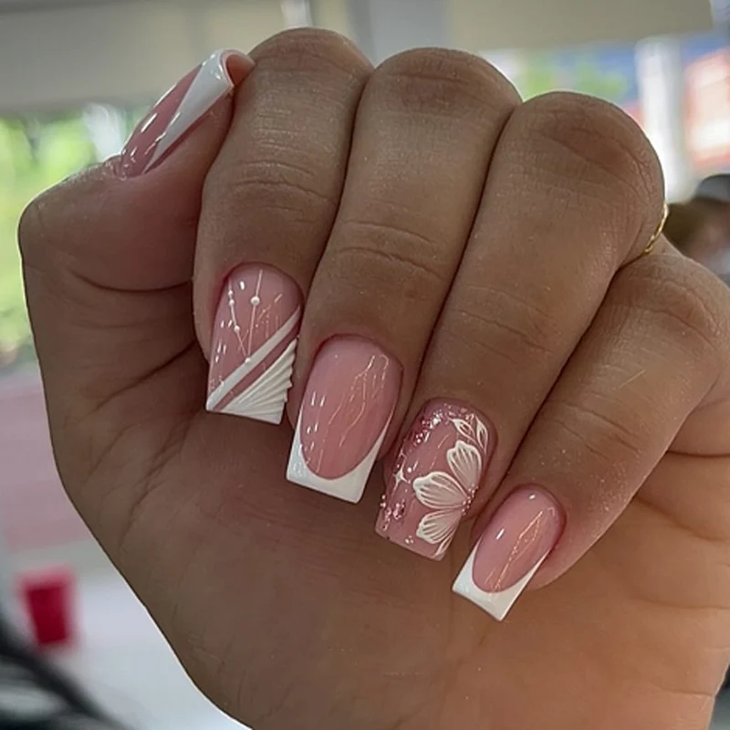 Kunstvolle Nagelkunst mit eleganten französischen Spitzen und floralen Akzenten Karnz