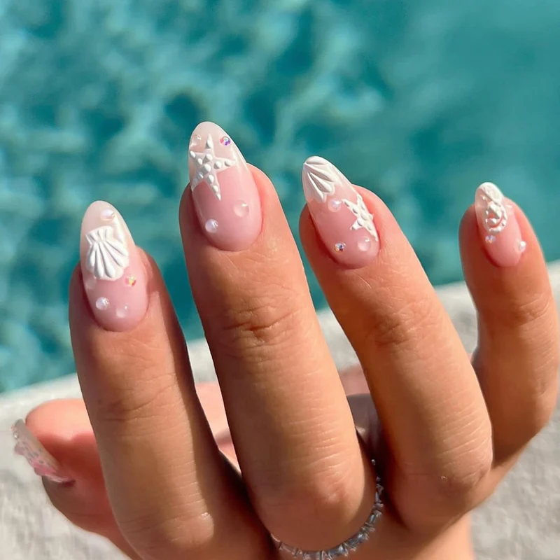 Kunstvolle Nagelgestaltungen mit Muschel- und Sternmotiv Karnz