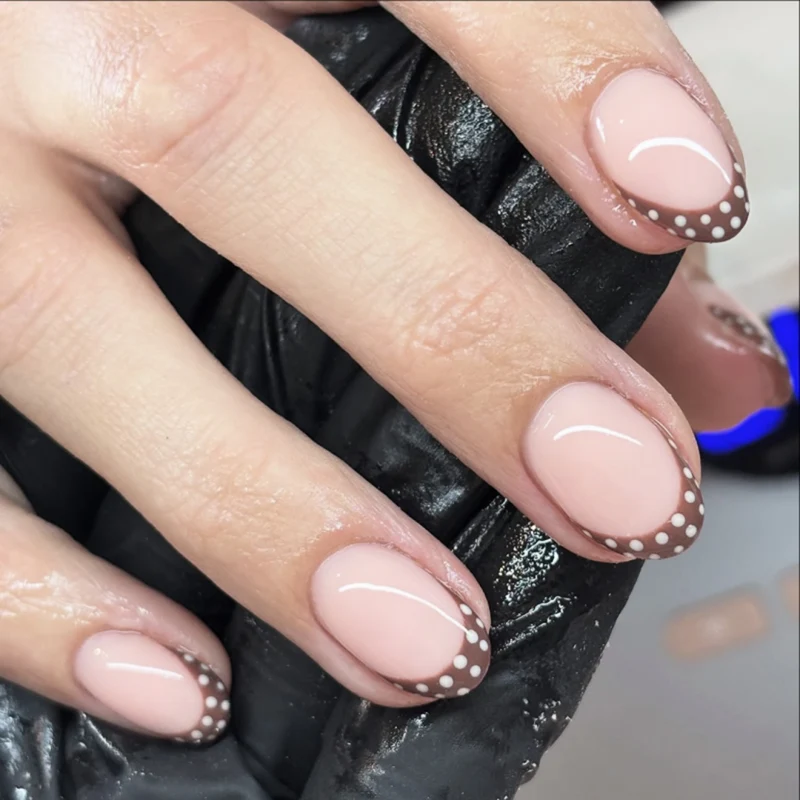 Kunstvolle Nagelgestaltung mit elegantem French-Tip und Akzenten Karnz