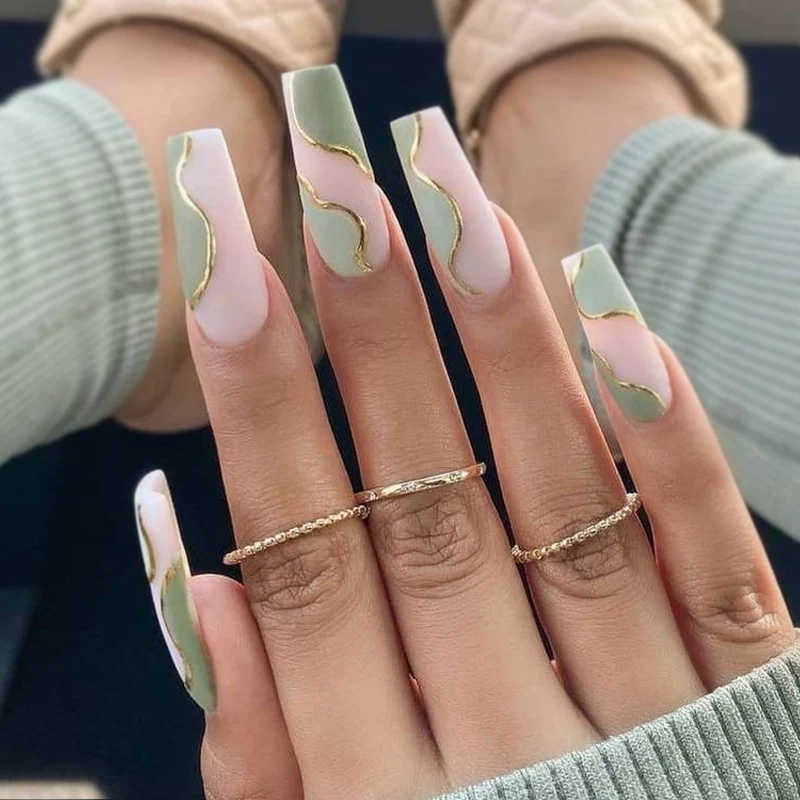 Kunstvolle Gel-Nägel mit elegantem Wellen-Design und Goldakzenten Karnz