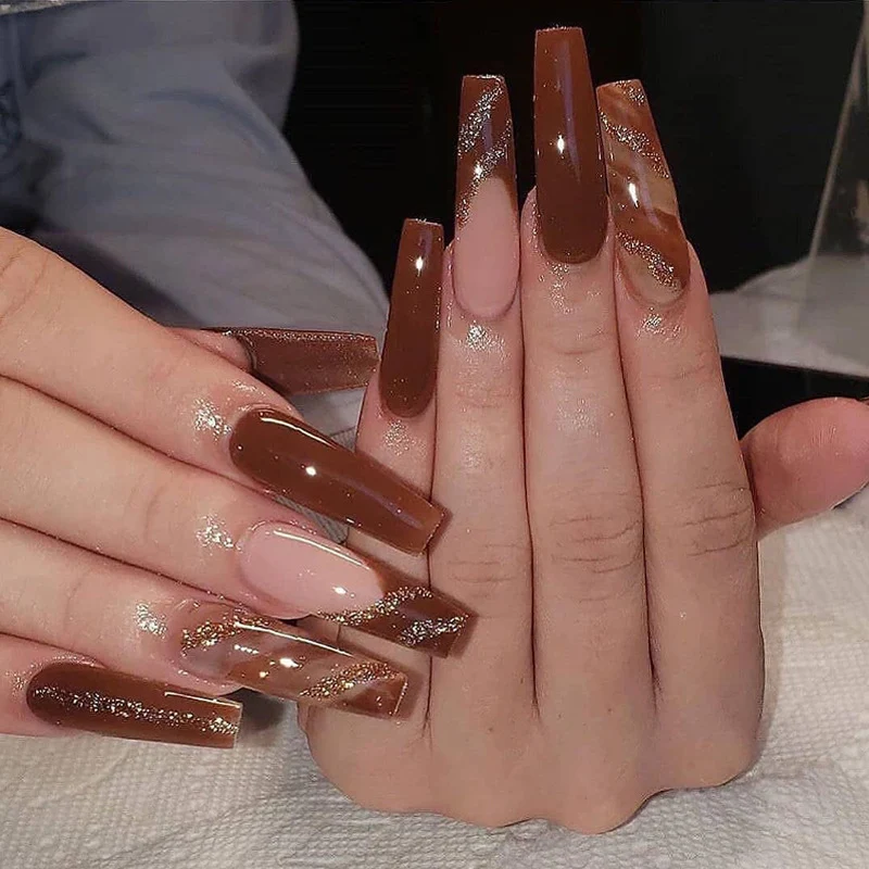 Kunstvolle Gel-Nägel im eleganten Hochglanzdesign mit Glitzerakzenten und stilvollen Mustern Karnz