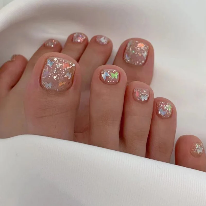 Kunstvolle Fußnagelkunst mit Glitzer und Schmetterlingsmotiven Karnz