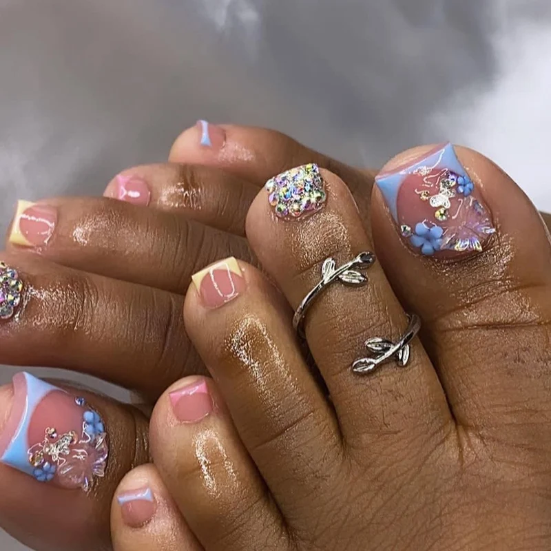 Kunstvolle Fußnagelkunst mit Glitzer- und Blütenmotiven Karnz
