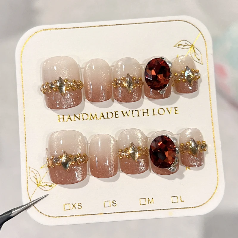 Künstliche Nagelkunst mit Glitzer- und Schmuckverzierungen Karnz