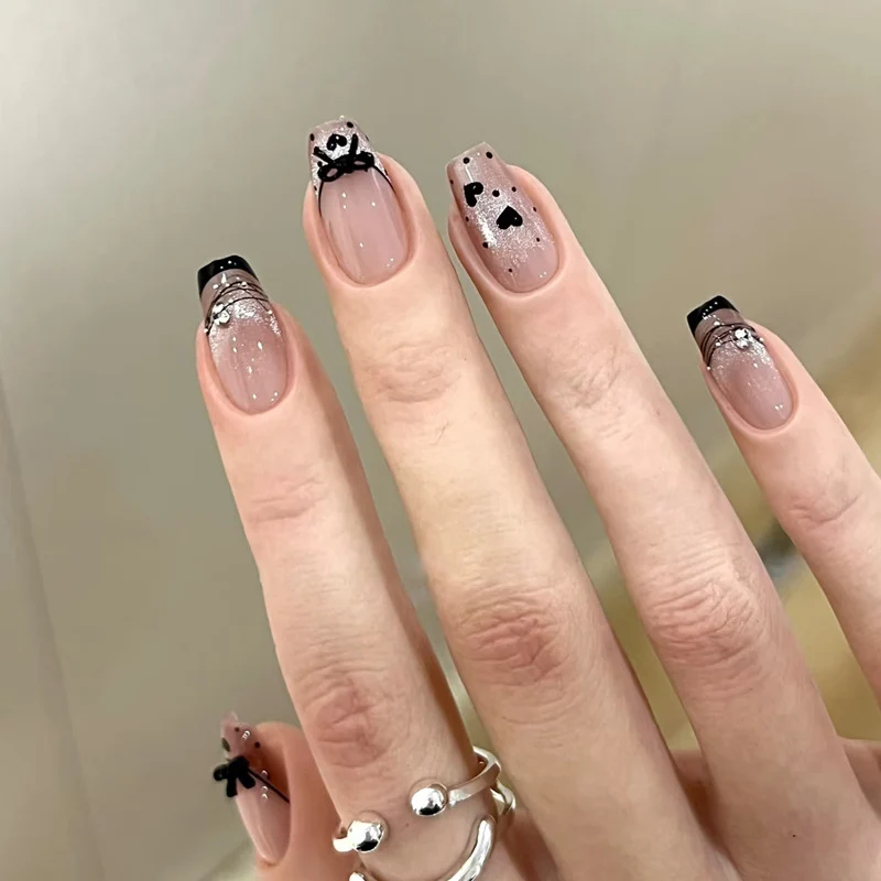 Elegantes kunstvolles Nageldesign mit Schleifen- und Glitzerelementen Karnz