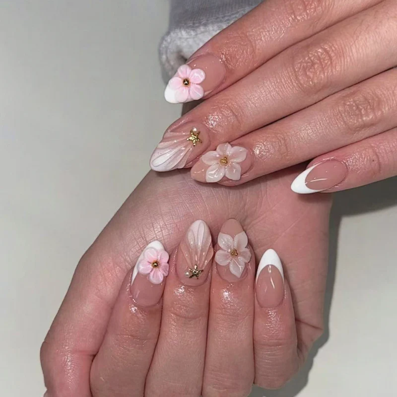 Elegante Kunstnägel mit floralem Design und Glitzerakzenten Karnz