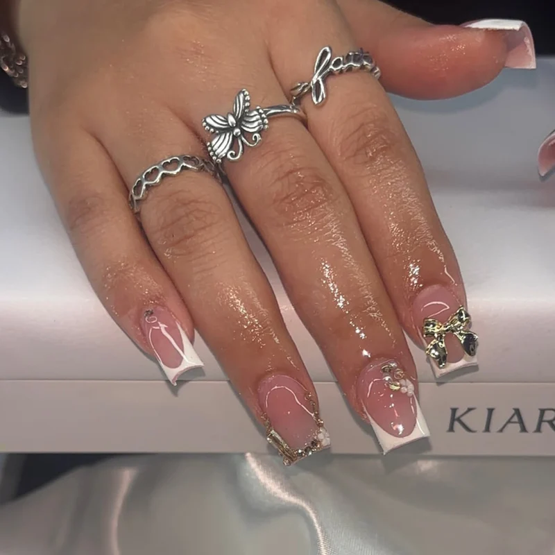 Elegante Nagelverlängerungen mit französischer Spitze und dekorativen Akzenten Karnz