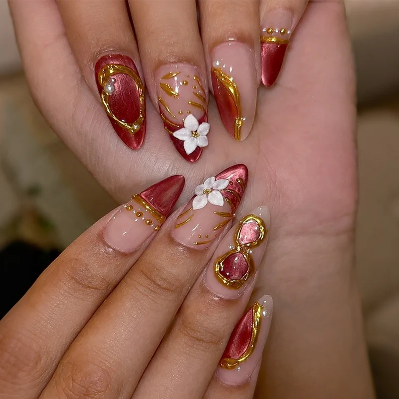 Kunstnagelset mit floralen und glamourösen Goldverzierungen Karnz