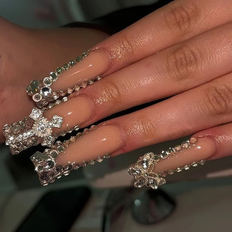 Glamouröses Kunstnagelset mit funkelnden Strass- und Kreuzverzierungen Karnz